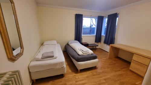 a small room with a bed and a mirror at Igdlo Guesthouse in Reykjavík