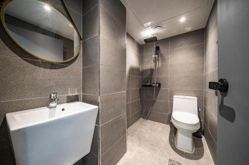 a bathroom with a toilet and a sink and a mirror at Lime Hotel in Busan