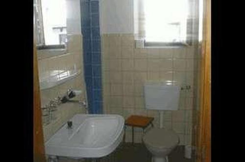 W łazience znajduje się toaleta, wanna i umywalka. w obiekcie Cad Maté 2 w mieście Maloja