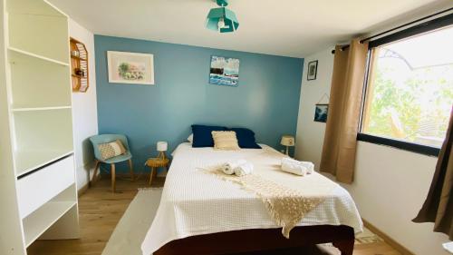 a blue bedroom with a bed with towels on it at L'oasis tropicale in Bras-Panon