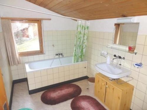a bathroom with a tub and a sink and a window at Ferienhaus in Quinten-Au in Quinten