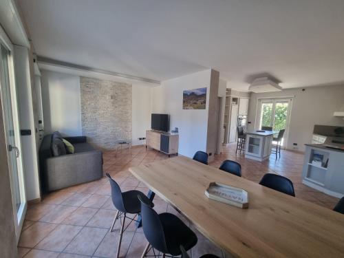uma sala de estar com uma grande mesa de madeira e cadeiras em Suite vacanze Chabloz nel cuore della Valle d'Aosta em Nus