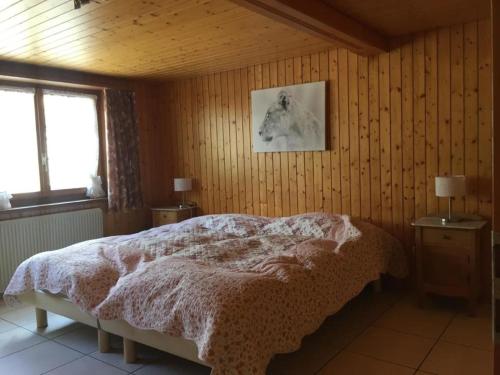 una camera con un letto su una parete in legno di Frohmatt ad Adelboden