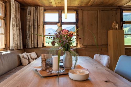 a wooden table with a vase of flowers on it at Voglen 2 in Nesselwang