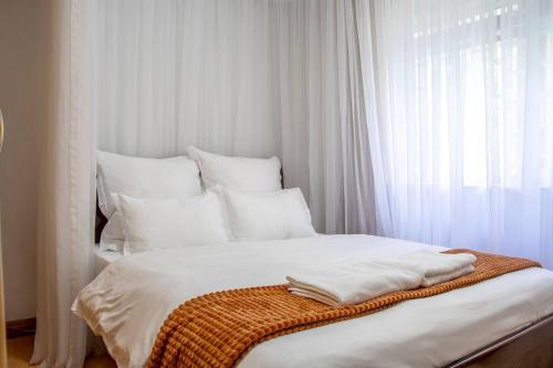 a white bed with white pillows and a blanket on it at Unique 2BR United Nation bluezone perimeter in Nairobi