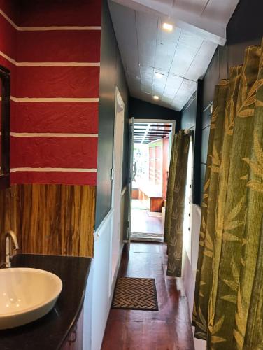 a bathroom with a sink and a hallway with a door at Lakenest overnight in Alleppey