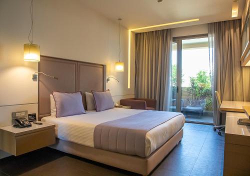 um quarto de hotel com uma cama grande com almofadas roxas em Saifi Suites em Beirute