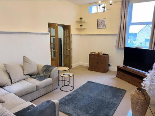 un salon avec un canapé et une télévision à écran plat dans l'établissement Beautiful Countryside Cottage Alnwick, à Alnwick