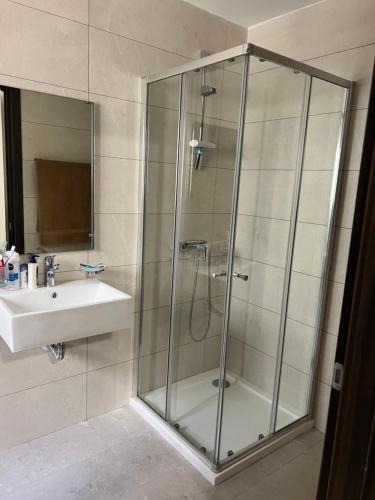 a bathroom with a glass shower and a sink at Penthouse with 3 bedroom in Luqa