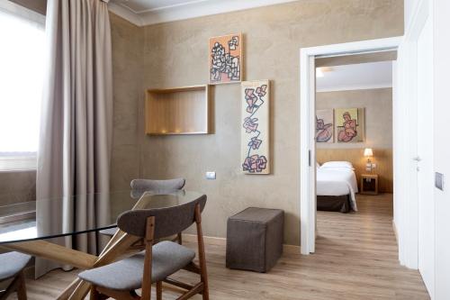 Best Western Plus Park Hotel Pordenone في بوردينوني: غرفة مع طاولة وكراسي وسرير