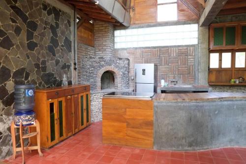 een keuken met een aanrecht en een stenen open haard bij Riverside villa in tropical setting in Jarakan