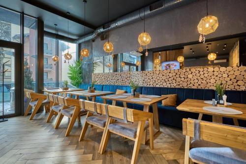 a restaurant with wooden tables and a blue couch at Twins Hotel & Spa in Bukovel