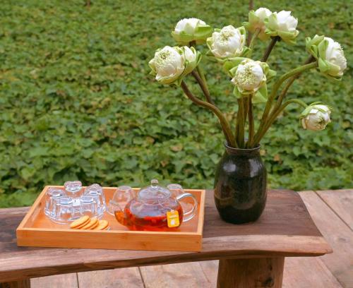 een vaas met witte bloemen op een houten tafel bij Một căn nhà gỗ ấm áp in Xuan An