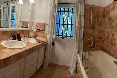 une salle de bain avec deux lavabos, une baignoire et une douche dans l'établissement Mas de la Lône, à Saint-Rémy-de-Provence