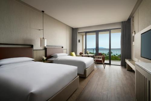 una camera d'albergo con due letti e una televisione di Sanya Marriott Yalong Bay Resort & Spa a Sanya