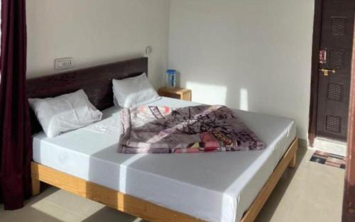um quarto com uma cama e uma cabeceira em madeira em Hotel Village Inn by StayApart em Barkot