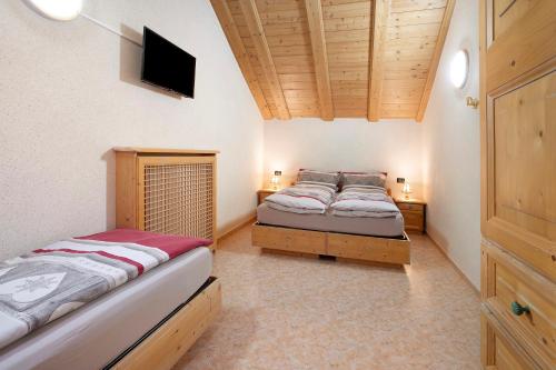um quarto com duas camas e uma televisão na parede em Appartamento Gemma em Livigno