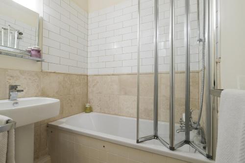 een badkamer met een bad en een wastafel bij The Carriage House in Blockley
