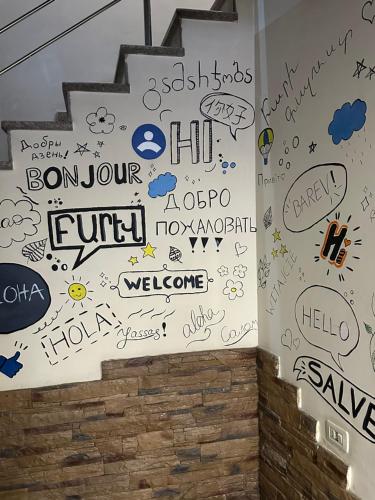 a wall covered with graffiti on a wall at ABC HOTEL in Yerevan