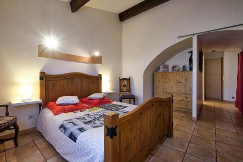 um quarto com uma grande cama de madeira num quarto em JARDIN STE ANNE em Carcassonne