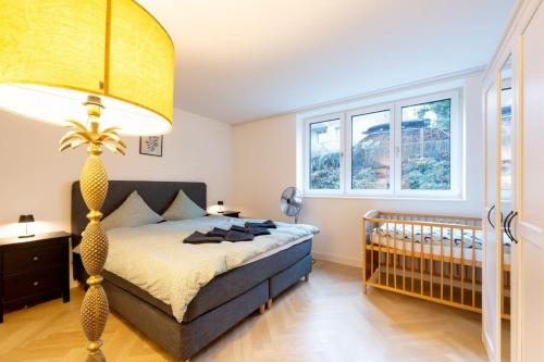 a bedroom with a bed and a baby crib at Ground floor apartment - Peaceful living in the city of Zürich in Zürich