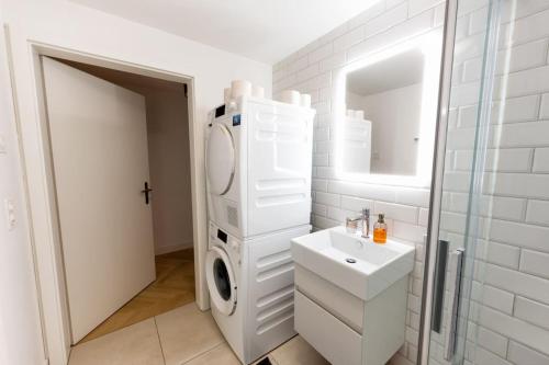 a bathroom with a sink and a washing machine at Ground floor apartment - Peaceful living in the city of Zürich in Zurich