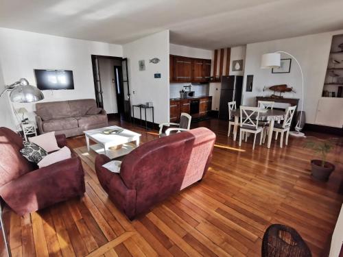 una sala de estar con un sofá y una mesa en Appart Gîte Les Oiseaux- face Loire Quai du Châtelet, en Orléans