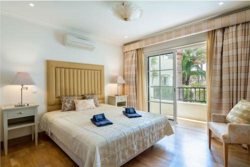 um quarto com uma cama com duas toalhas azuis em Palmyra by Intiholidays em Vilamoura