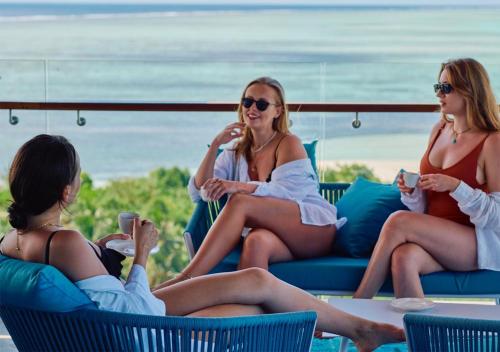 three women sitting in chairs on the beach at Stone Hotels Dhiffushi in Dhiffushi