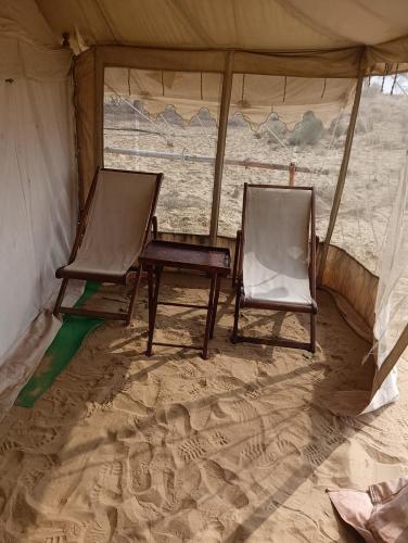 two chairs and a table in a tent at Bikaner Desert Camp and Resort in Bikaner