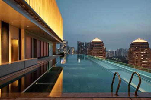 a swimming pool on top of a building with a city skyline at COMO Metropolitan Singapore in Singapore