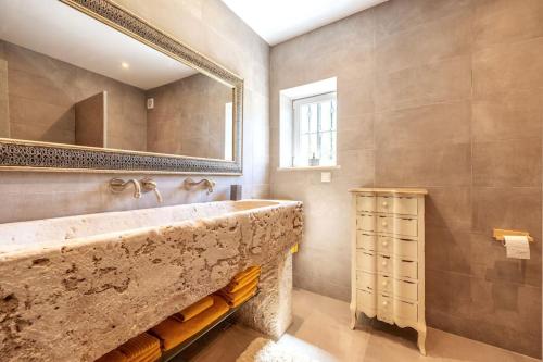 a bathroom with a large stone sink and a mirror at Luxurious & Famous Villa of Dutch TV Show in Budens