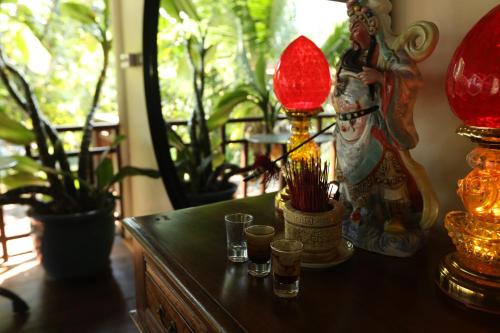 a table with some lamps and glasses on it at Devi Kampot Resort at Phum Kampot in Kampot