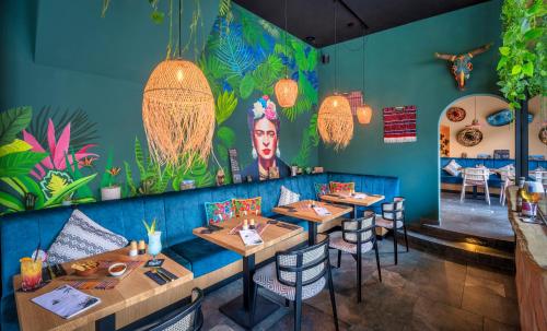 a dining room with tables and a colorful mural at Seehotel zur Post in Tegernsee