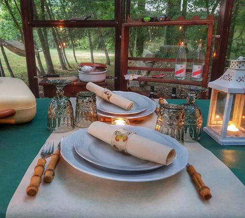 a table with plates and utensils on a table at Agriturismo Casanuova in Carobbio