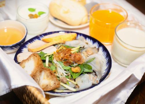 a plate of food with a salad and bread and drinks at Lantern Hotel in Ho Chi Minh City