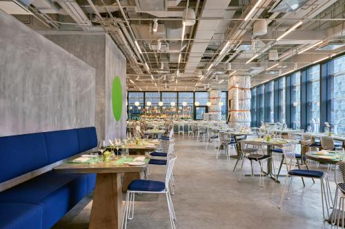 un ristorante con tavoli e sedie in legno e finestre di COMO Metropolitan Singapore a Singapore