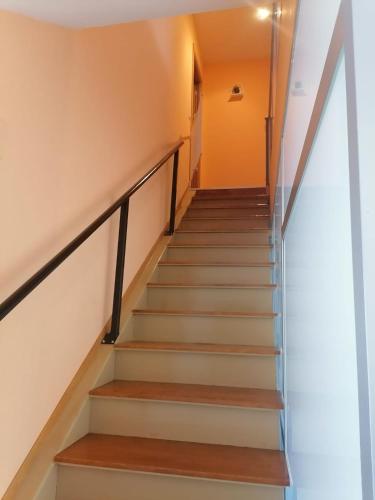 a staircase in a house with wooden stairs and orange walls at El Vergel del Piedra in Munébrega