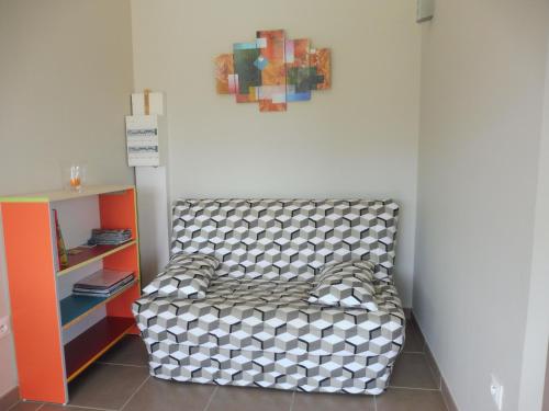 einen Stuhl in einem Raum mit einem Gemälde an der Wand in der Unterkunft Gîte Amour D'ardèche in Saint-Sernin