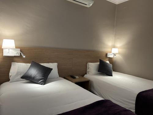 two beds sitting next to each other in a room at Hostal Restaurant Roma in Cubells