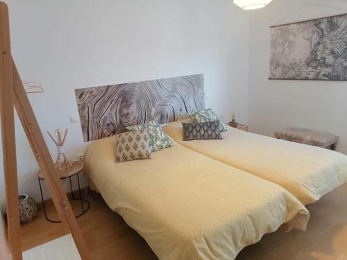 a bedroom with two beds and a wooden headboard at El Vergel del Piedra in Munébrega