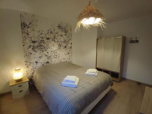 une chambre avec un lit avec deux serviettes dessus dans l'établissement Chez Mémère, à Colleville-sur-Mer