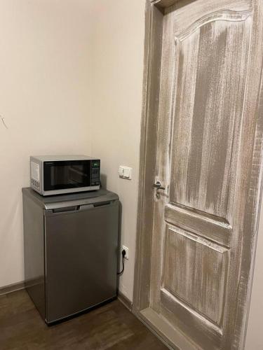 a door with a microwave on top of a refrigerator at Studio apartamenti Cēsis in Cēsis