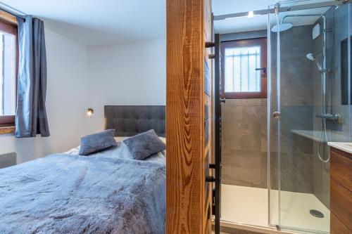 um quarto com uma cama e uma cabina de duche em vidro em Megève - Appartement - 1 Chambre em Demi-Quartier