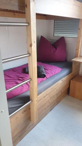 - łóżko piętrowe z fioletowymi poduszkami w pokoju w obiekcie Gletscher-Trail Hostel w mieście Flattach