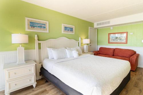 ein Schlafzimmer mit einem großen Bett und einem roten Sofa in der Unterkunft Superb 3rd Floor Oceanfront King Room in Pawleys Island