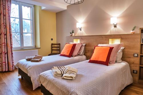- deux lits dans une chambre d'hôtel avec deux couvre-lits dans l'établissement L'Hôte de la Couronne, à Bar-le-Duc