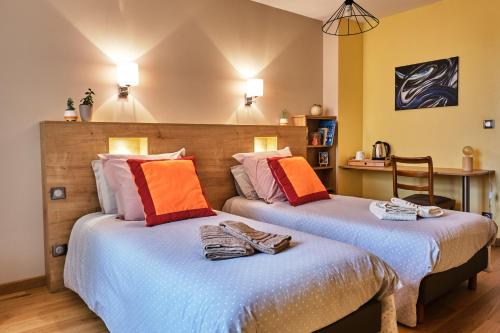 two beds sitting next to each other in a room at L'Hôte de la Couronne in Bar-le-Duc
