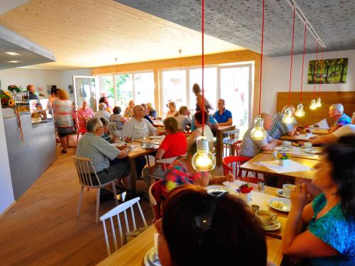 um grupo de pessoas sentadas em mesas em um restaurante em Winzercafe Neipperg Ferienwohnungen em Brackenheim
