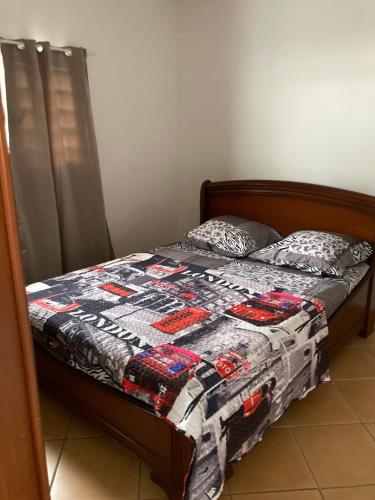 a bed with a quilt on it in a bedroom at Chez Mina in Saint-Louis